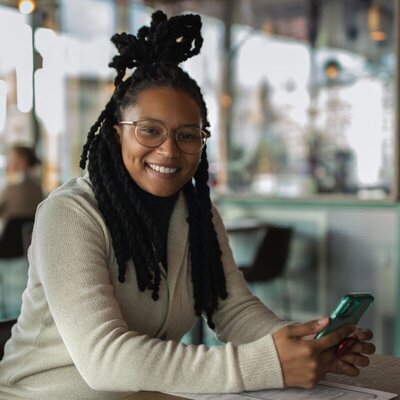 Alesia Hendley with a phone in hands smiling
