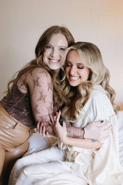 Holly, Klover Beauty co-founder, hugging a Maryland bride on her wedding day after providing hair and makeup services.