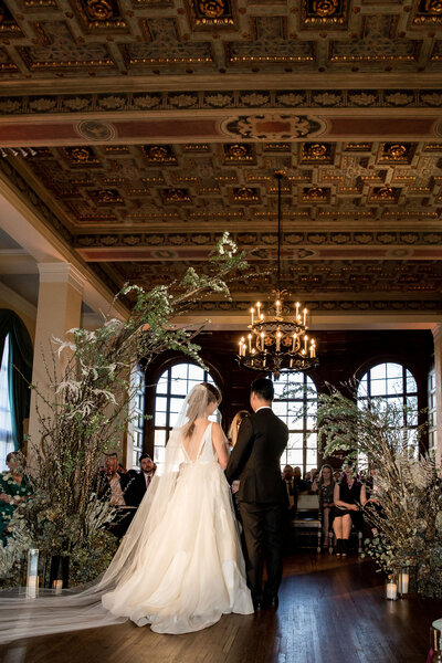 Bride and groom inside the Ebell of Los Angeles wedding venue at their whimsical ceremony in the round.