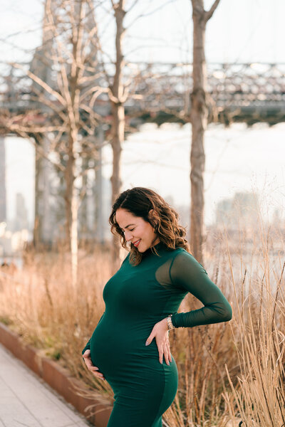 a mother looks down at her belly in williamsburg