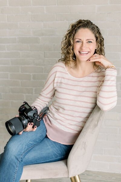 Photographer and Nikon Shooter poses with camera for headshot