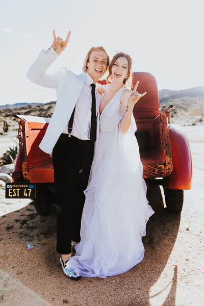 Elopement Photographer,  bride and groom stand before old truck with rock n' roll hand gestures