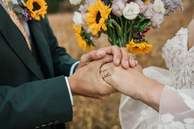 A bride and groom laugh together at sunset on Lake Dillon