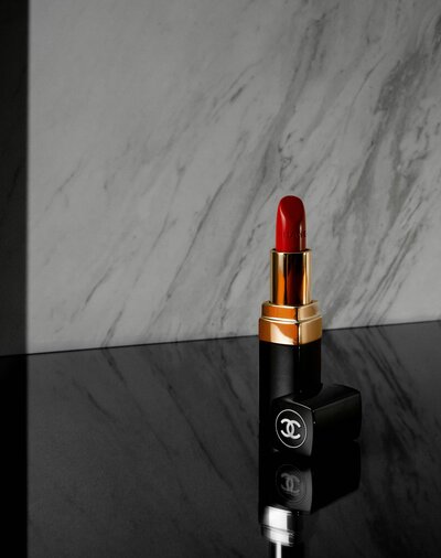 Chanel red lipstick in front of a marble wall