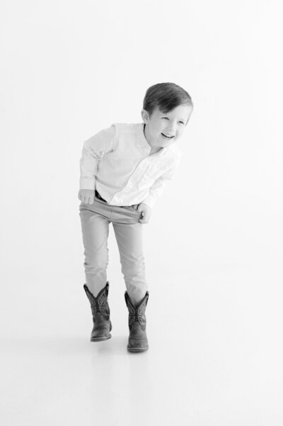 Young boy in cowboy boots in Portrait Studio Session in Tulsa, Oklahoma with Caroline Eidson Portraits