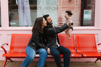 Baby wearing beanie looking at camera while being held by father