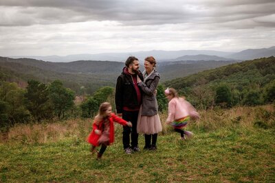 Parents with their two daughters running around them photographed with motion blur at Olinda