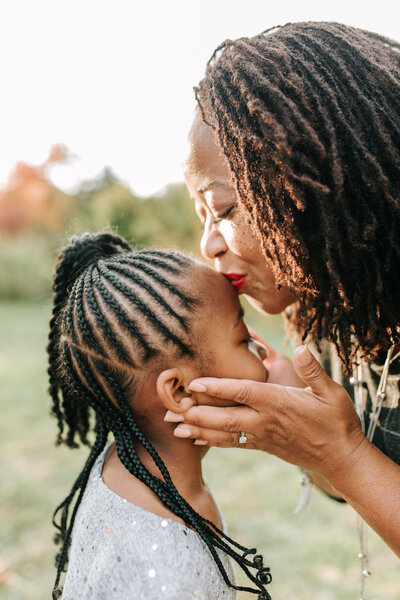 Mother kissing daughter's forehead