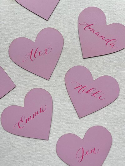 Pink heart place cards for Valentine's Day with calligraphy