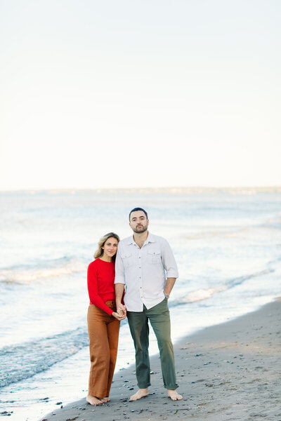 Couple posing on the beach during their engagement session at Lake Ontario.