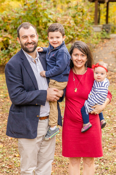 Family of four standing with kids in parents arms