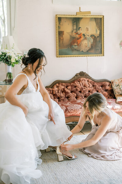 Intimate bridal preparation captured by a San Francisco wedding photographer, highlighting the beautiful bond between the bride and her bridesmaid.