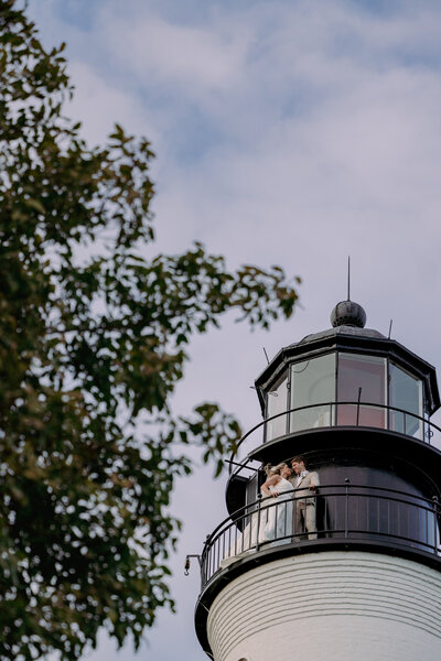 man and woman standing on a structure above the ocean