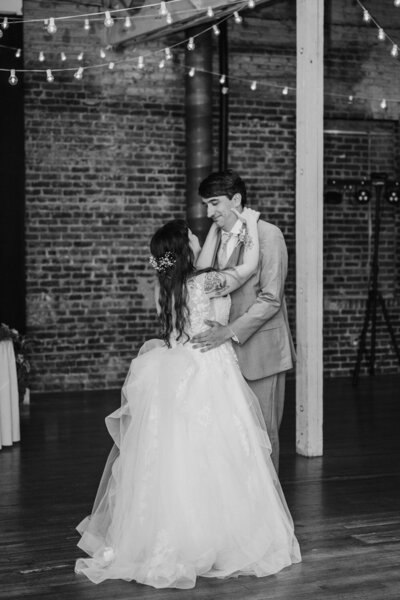 Couple dancing during first dance in black and white