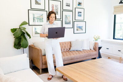 Dinah standing in her office working on her Macbook