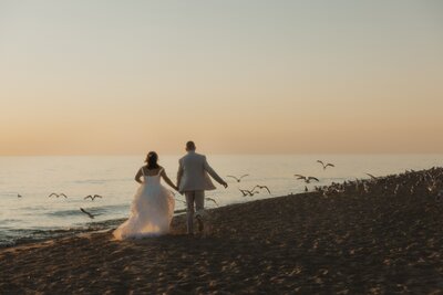 couples elopement at the beach, running along the sand