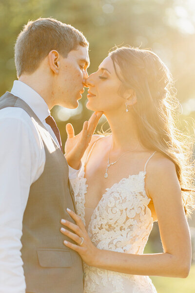 bride and groom kissing in golden hour sunset