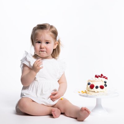 Vrolijke cakesmash fotoshoot voor de eerste verjaardag, met kleurrijke taart en feestelijke setting bij Studio 2Shoot in Eijsden.