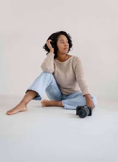 Photographer sitting on the floor next to a camera