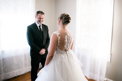 Bride hugging her father after seeing each other for the first time in wedding attire