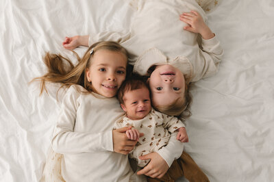 pasgeboren baby met mama , papa en  zus