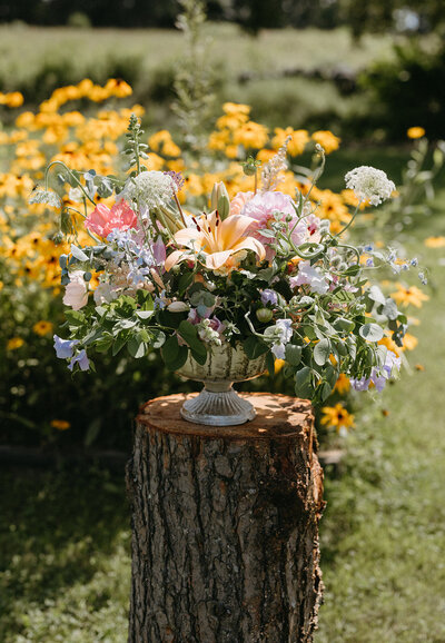 Colorful floral decor arranged at an outdoor wedding ceremony