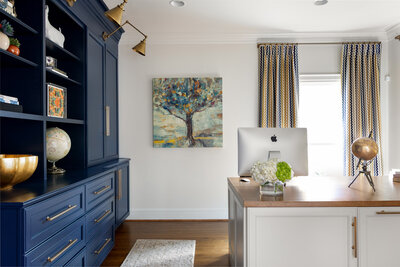 Modern traditional home office design with custom blue cabinetry and white desk.
