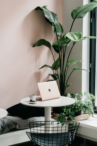 Open computer on table near a window