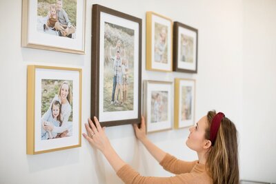 metallic framed photos being placed on the wall