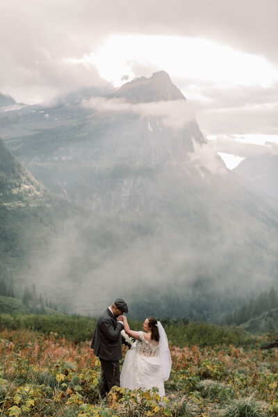 bride and groom in front of mountains