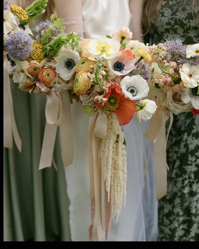 close-up of colorful wedding bouquet wrapped in soft ribbons against green foliage in Kansas


