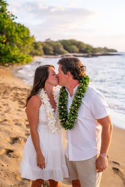 Detail photo of a couple wearing traditional Hawaiian leis during a beach proposal at ʻAnaehoʻomalu Bay in Waikoloa, photographed by Hawaii Adventure Portraits, a Big Island proposal photographer