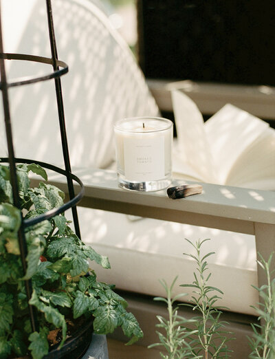 outdoor chair with book, Detroit Rose Smoked Tomato candle, palo santo, tomato plant and herbs, film branding photo for candle company