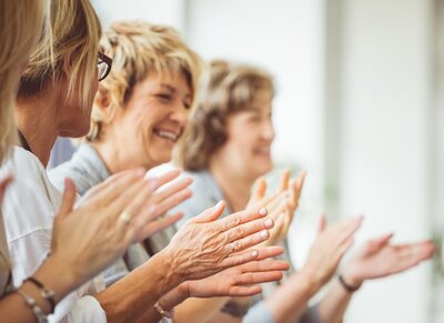 women clapping at a presentation