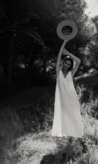 a young woman wearing a hat and a white dress