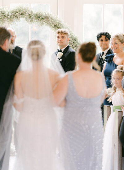 Bride walking down the aisle towards the groom during an indoor wedding ceremony, captured by Nashville wedding photographer Diana Marie.