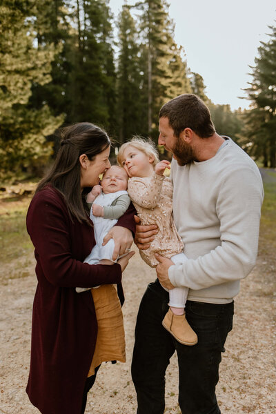 Candid photo of a couple holding their two children and smiling