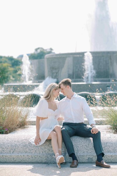couple sitting at a fountain during the engagement session in DC