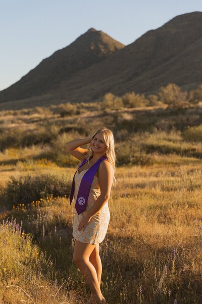 girl poses in arizona desert for graduation photos