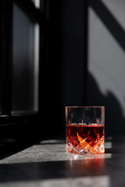 Negroni in het zonlicht. Grijze achtergrond bij raam Bisque Groningen. Fotografie door Dorien Paymans | Studio Ensō Groningen ©