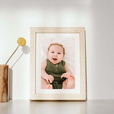 framed baby photo of baby girl in green smiling captured by Branson MO baby milestone photographer Jessica Kennedy of The Xo Photography