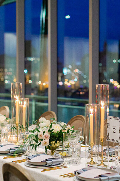 A beautifully set and decorated table in Le Belvédère reception hall, with a breathtaking view of Old Montreal. Best Montreal Wedding Venue.