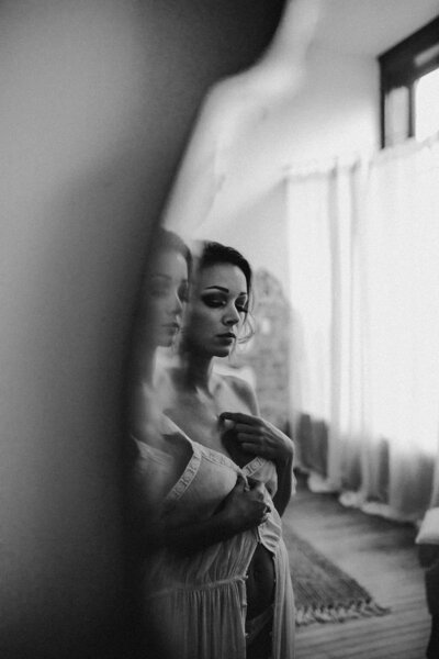 black and white image woman looking in mirror