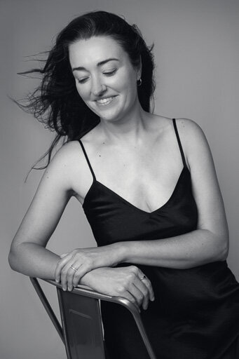 Portrait of a classy elegant woman leaning on the chair and smiling.