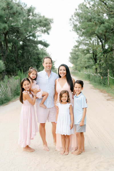 Cute family with three boys plays in a field during the fall