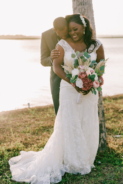 Bride & Groom look happy near the water at Wilmington Plantation wedding venue in Savannah GA. Savannah wedding photographer.