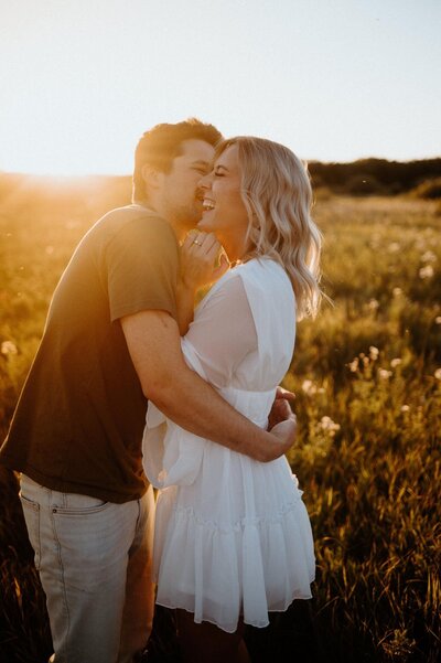 Couples session in field at sunset