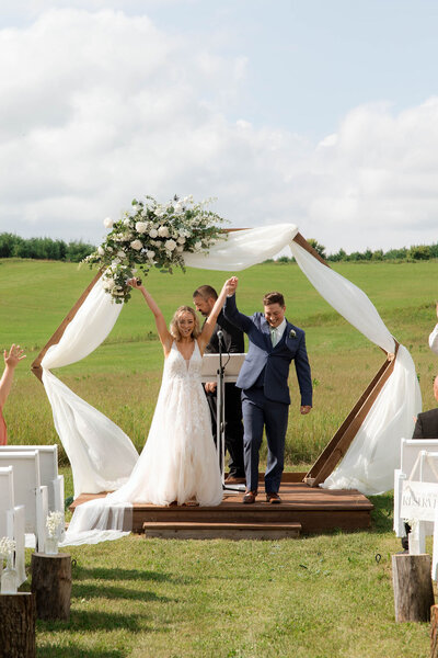 Couple saying their vows and celebrating their wedding after walking down the aisle in front of their family.