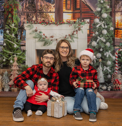 Frozen Moments by Kathy Photography | Family Christmas session with a fireplace in the background. Family is dressed in red and black buffalo plaid