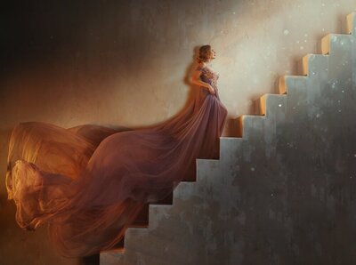 A beautiful blonde woman in a flowing dusty-rose dress ascends a stone staircase toward an unknown source of light.